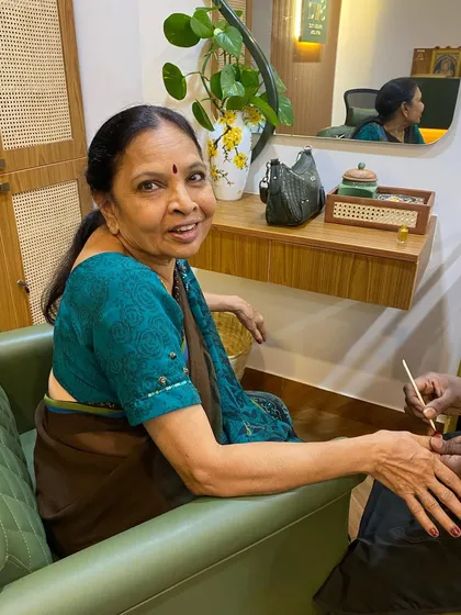 A senior client smiling as she receives a meticulous manicure from one of our therapists. We take pride in providing gentle and attentive care.