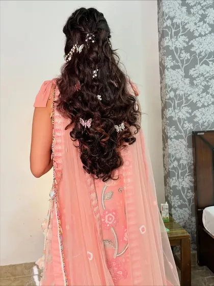 Hairstyling is my passion, and this whimsical Mehendi look shows why. I crafted intricate curls and braids, weaving in delicate butterfly and pearl accessories for a truly magical, fairytale vibe.