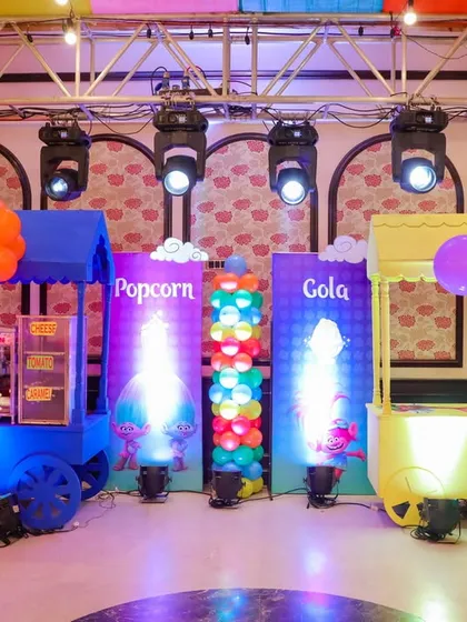 Popcorn and cola carts are a must-have for a party! These are decorated with colorful balloons and Trolls branding to fit the theme perfectly.