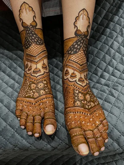 A gorgeous peacock-themed design for the feet. The peacocks are the star of the show, with their feathers flowing down the foot. Jhumka motifs add a touch of sparkle.
