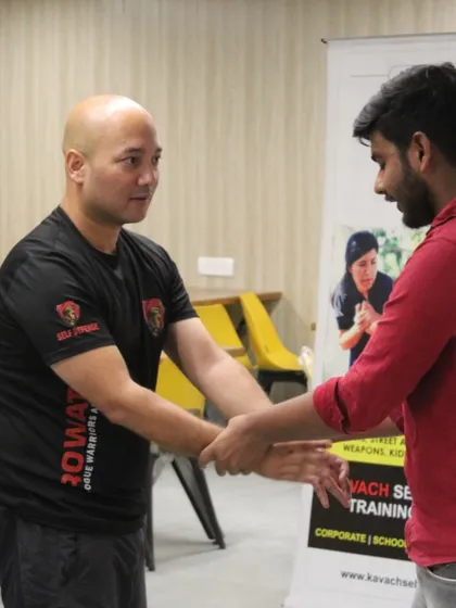 Demonstrating a wrist grab escape during a corporate training session for women.