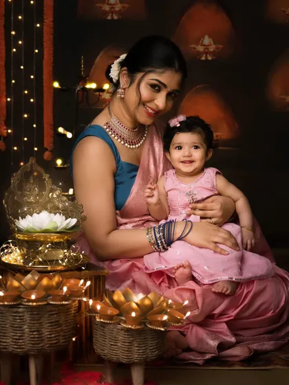 A mother and her daughter share a lovely moment during their Diwali photoshoot, surrounded by glowing lotus diyas.