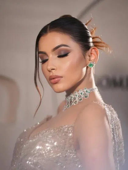 An eyes-closed portrait, highlighting the flawless makeup. The styling is designed to create a look of pure serenity and glamour.