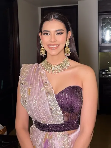 Rhinestone romance and silver lining magic for Kavya’s welcome dinner. The purple and lavender sari is paired with dramatic, shimmering eye makeup.