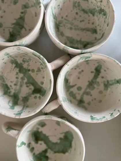 An overhead shot of the splash-glaze mugs. This view really shows the unique, spontaneous pattern inside each cup.