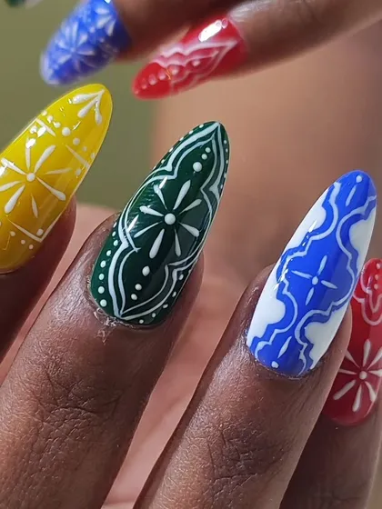 Every detail matters, especially for festive occasions. This is a close-up of a hand-painted Navratri nail set, showcasing the intricate white line work on bold, vibrant colors. I love creating custom designs that help you celebrate in style.