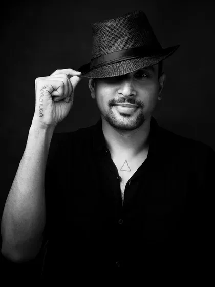 The black and white version of the fedora shot. It adds a timeless, cinematic quality to the portrait, emphasizing the mystery and charm of the pose.