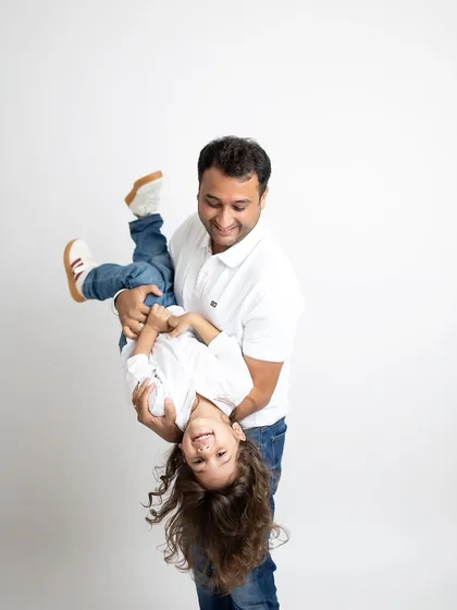 It's the playful, unscripted moments that often make the best memories. I love capturing the fun side of family, like this shot of a father playfully holding his child upside down during our studio session.