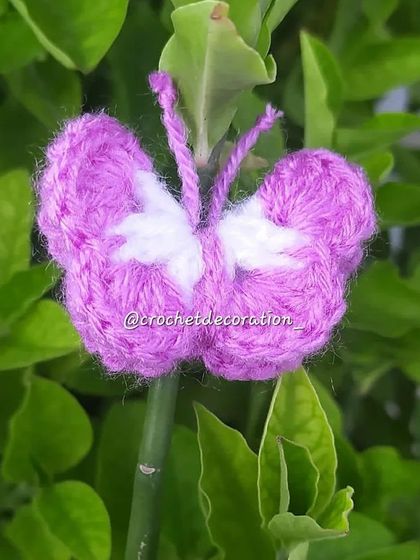 A delicate crochet butterfly in purple and white. These can be used as decorative elements on bouquets, as hair clips, or attached to a keychain.