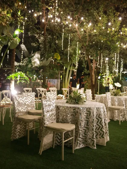 The perfect setting for a pre-wedding cocktail party or sangeet night. The lawn provides ample space for a dance floor, while the surrounding trees, lit with elegant chandeliers and string lights, create a festive and celebratory atmosphere.