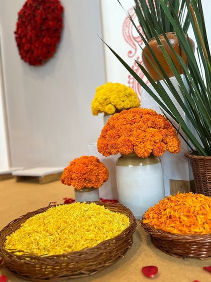 Vibrant marigold arrangements in yellow and orange add a traditional and colorful touch to the minimalist Bindi-themed decor.