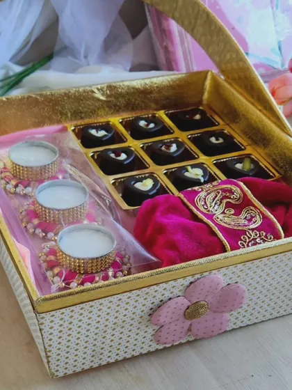 A beautiful Diwali gift hamper featuring a box of our handmade chocolates, festive diyas, and other traditional touches. We customize these baskets to make your corporate gifting feel personal and special.