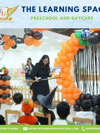 A teacher dressed as a witch leads a puppet show for an enchanted audience. Storytelling and performance are key elements of our magical events.