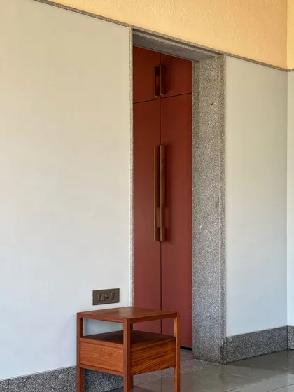 A detail from a project with colors by Malene Bach. The warm red of the doors contrasts with the cool grey of the granite trim and the neutral wall, creating a balanced and harmonious composition.