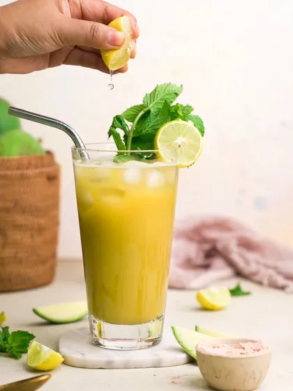 A refreshing glass of Aam Panna, shot for a health-focused brand. The bright, clean lighting and fresh mint garnish emphasize the natural and cooling properties of the drink.