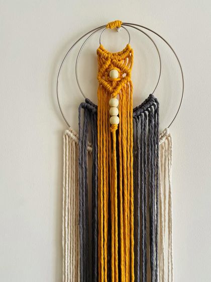 I call this design 'Synergy'. It's a multi-colored dream catcher with wooden beads and a double ring design. It's a unique piece for a bright corner.