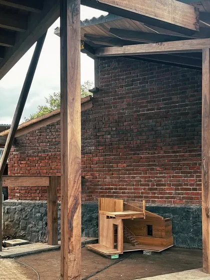 The 1:5 scale wooden model of the staircase sits in front of the full-scale structure. This comparison highlights our design-build process, moving from detailed models to handcrafted reality.