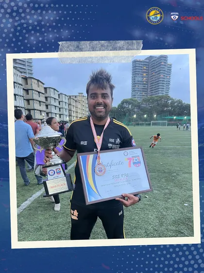 A coach from our U15 team holds the trophy and certificate, a symbol of the team's hard-earned success. We focus on developing complete footballers who can rise to any challenge.