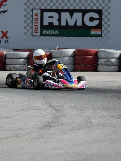 A junior driver in a pink and blue kart navigates the track during the RMC.