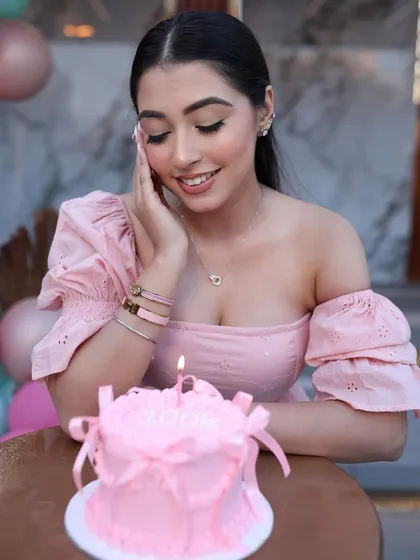 A moment of celebration with the personalized pink bento cake, complete with a single candle.