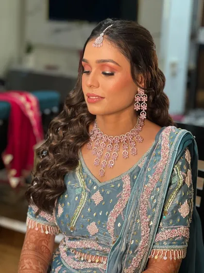 A serene portrait showing the details of the eye makeup and the delicate pink jewellery.