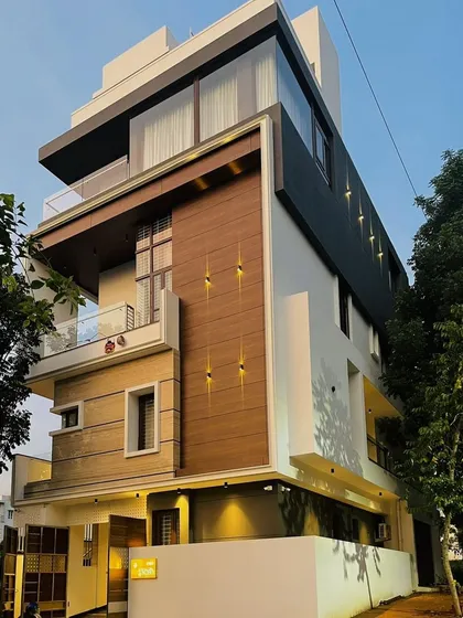 The striking geometric facade of a modern residence at dusk. The strategic use of exterior lighting accentuates the building's form and the interplay of different materials.
