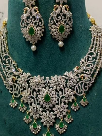 A delicate and intricate choker set with green stones and pearl drops. This piece is perfect for bridesmaids or for a more understated reception look.
