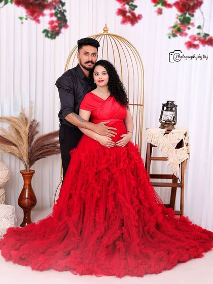 A beautiful couple's portrait in our bohemian studio setup, with the mother-to-be in a red ruffled gown.