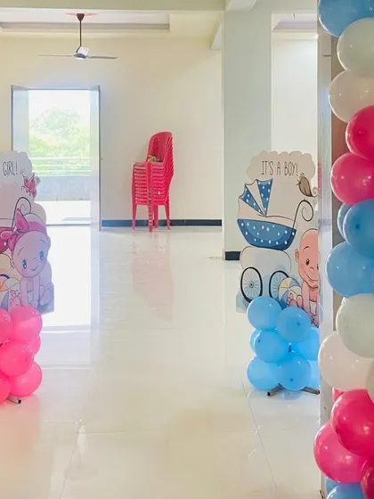 Gender reveal themed cutouts and balloon pillars placed inside the home for a baby shower celebration.