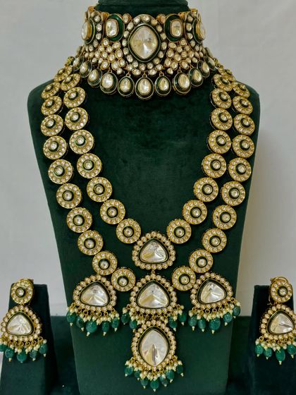 A full view of the long, layered necklace set with triangular Kundan pendants. This rental piece is perfect for creating a dramatic bridal look.