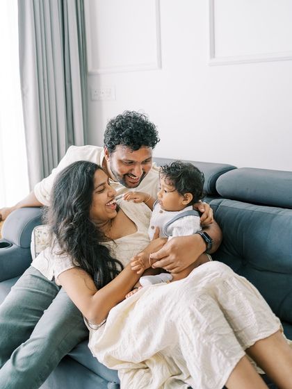 A family playing together on the sofa. The baby's interaction with his parents is the heart of this photo.