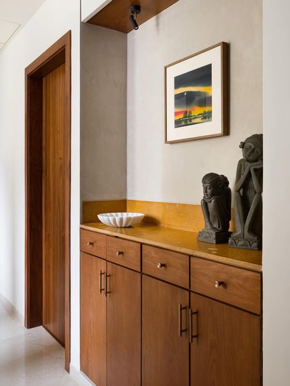 This entry alcove features a custom teak cabinet with a vibrant yellow Jaisalmer stone top. It's a piece designed to welcome you home with color, texture, and a place for your keys.