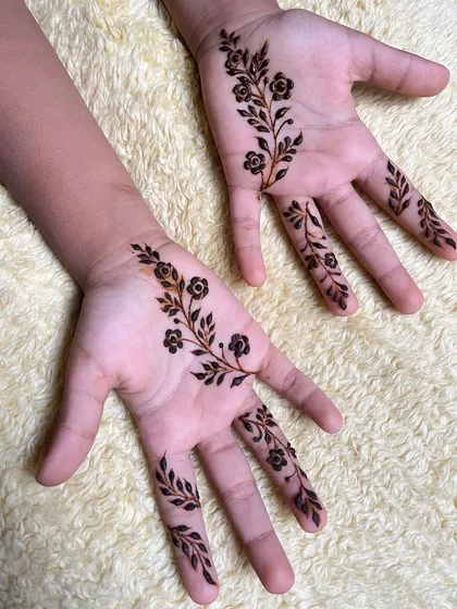 A simple and pretty floral vine design on the palms of a child's hands.
