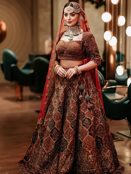 A full-length shot showing how the jewellery complements the rich, earthy tones of the bridal lehenga.