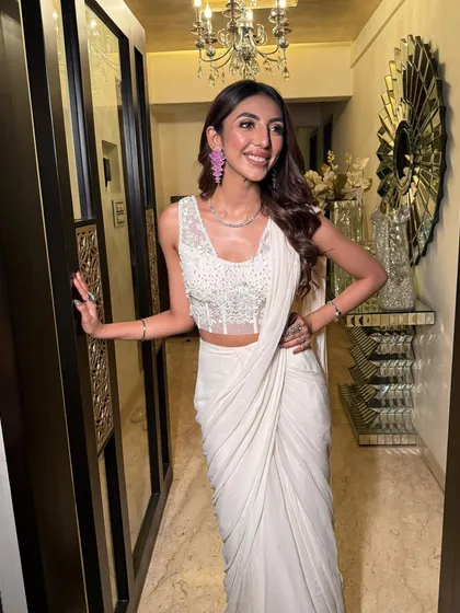 A full-length shot showing the elegant drape of the saree. The overall look is one of modern sophistication.