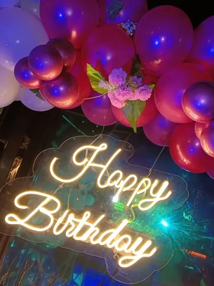 A simple but impactful 'Happy Birthday' neon sign surrounded by balloons. This is a great option for smaller spaces or more intimate celebrations.