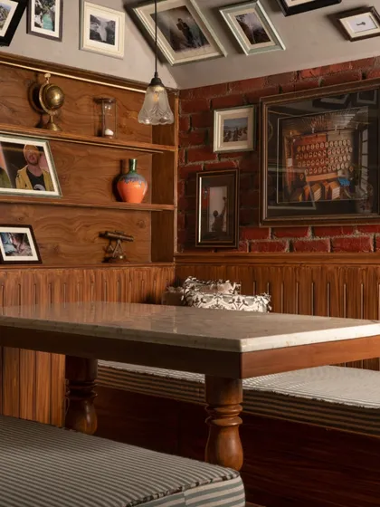 The booth seating at Echoes offers a nostalgic twist with its striped cushions and turned-wood table legs. This corner becomes the heart of the room, ideal for quiet moments or heartfelt conversations.