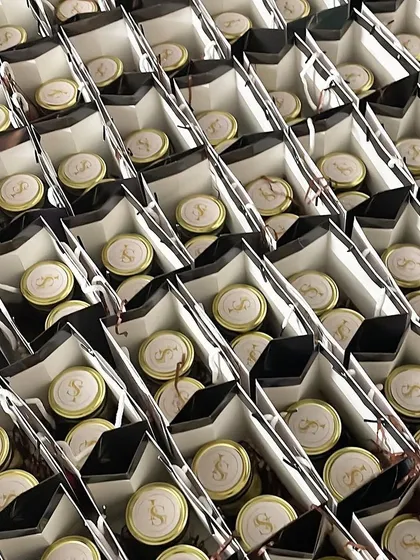A large order of wedding return gifts, all packed and ready to go. Each bag contains jars of our artisanal desserts with custom monogrammed lids.