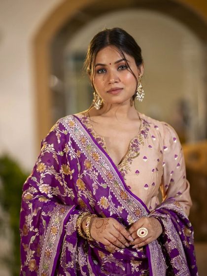 An intimate portrait that draws attention to the intricate embroidery on the neckline and the rich texture of the dupatta. This close-up view allows customers to appreciate the craftsmanship.