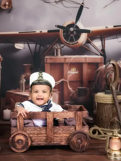 A grand adventure awaits! This wide shot shows our full travel and explorer theme, with a vintage airplane and wooden crates, creating an amazing backdrop for a six-month milestone session.