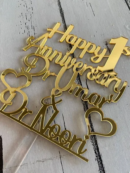 A detailed shot of the "Happy 1st Anniversary Dr. Umar & Dr. Noori" topper, showcasing its complex and personalized design.