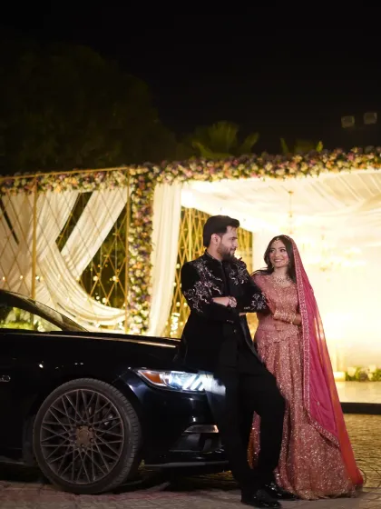 A stylish portrait of the couple with a luxury car at their reception. This image adds a touch of modern glamour to their wedding story.
