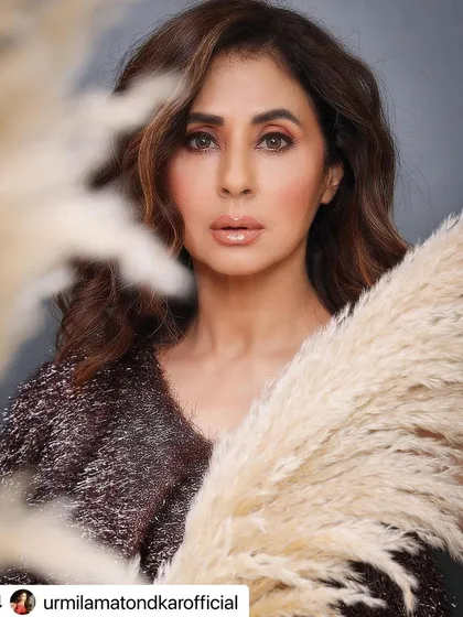 A creative portrait of Urmila Matondkar. Her hair is styled with soft, touchable waves that add to the artistic feel of the photo.