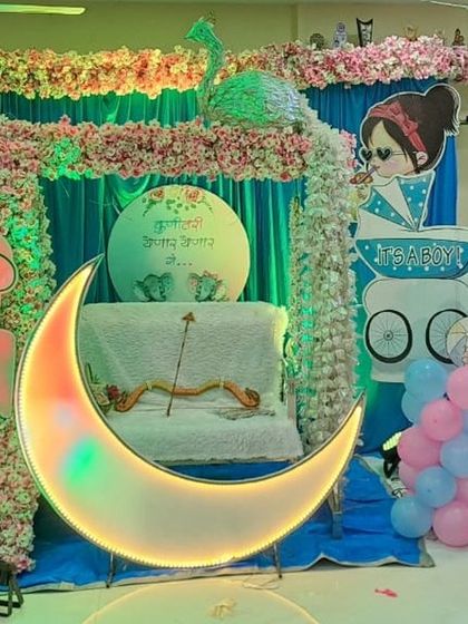 A colorful and fun baby shower decoration with a lighted moon prop and a 'Kunitari Yenar Yenar Ga' sign, perfect for celebrating the upcoming arrival.