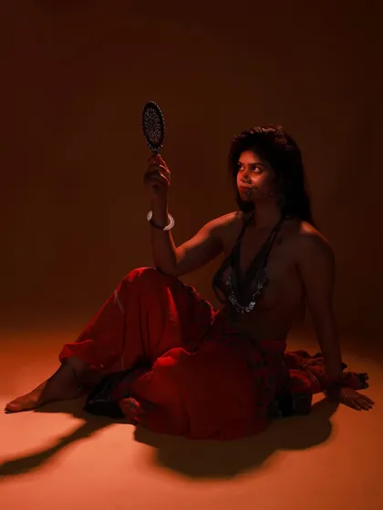 Another angle from the same conceptual shoot. The focus is on the model's intense gaze into the mirror, creating a sense of drama and introspection.