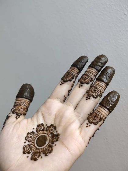 A simple and cute floral mandala on the palm with detailed finger bands.