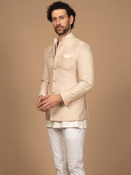 A side view of the peach embroidered bandhgala, showcasing its perfect fit and clean silhouette. It’s a testament to how bespoke tailoring can elevate even a simple design.