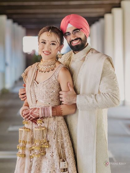 A happy portrait of the newly married Sikh couple, smiling brightly for the camera.