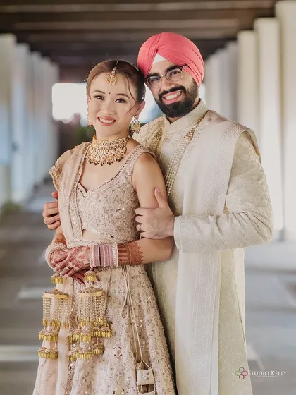 A happy portrait of the newly married Sikh couple, smiling brightly for the camera.