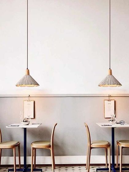 A pair of woven-shade pendant lights in a cafe setting, adding a natural and rustic charm.